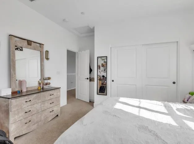 a spacious bedroom with a bed and a double vanity sink