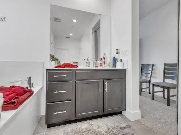 a bathroom with a sink cabinets and chair
