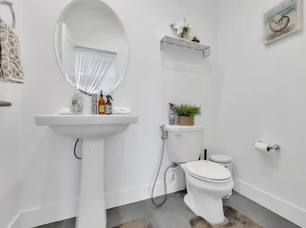 a bathroom with a sink a toilet and a mirror