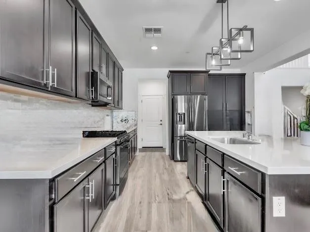 a kitchen with stainless steel appliances granite countertop a sink stove and refrigerator