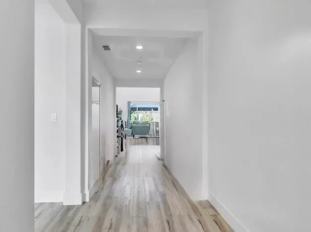a view of a hallway with wooden floor