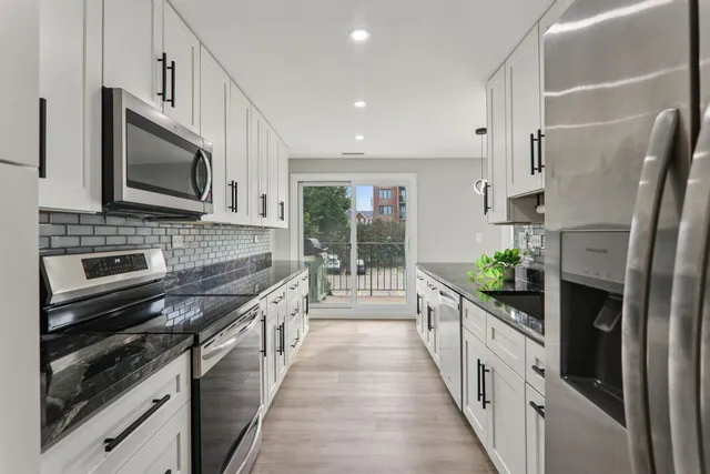 a kitchen with stainless steel appliances a stove microwave and a refrigerator