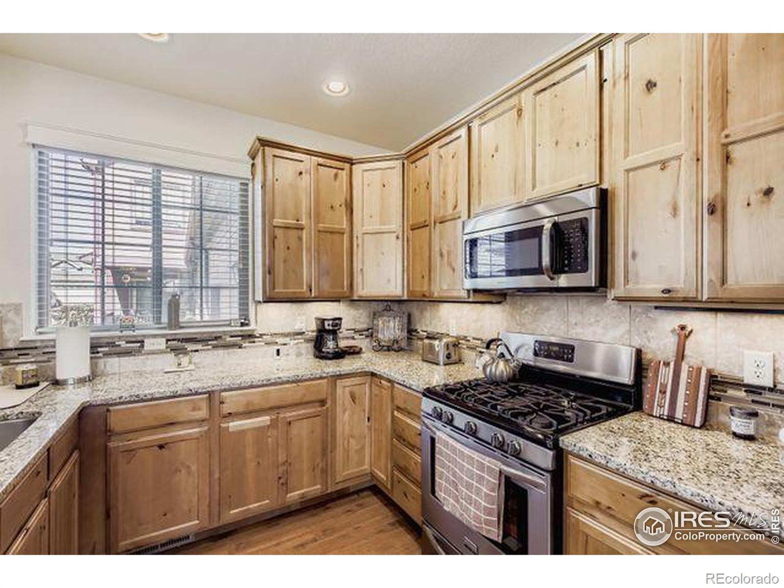 3453 Rhea Drive Loveland, CO 80537 - Photo 12 of 33 a kitchen with stainless steel appliances granite countertop a stove sink microwave and cabinets