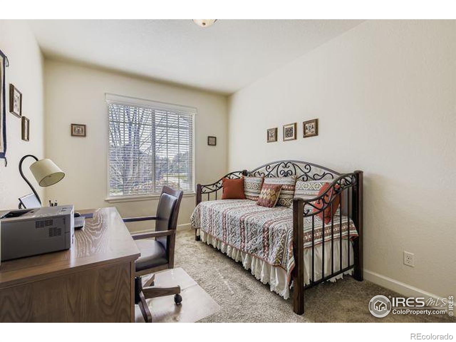3453 Rhea Drive Loveland, CO 80537 - Photo 19 of 33 a bedroom with a bed and wooden floor