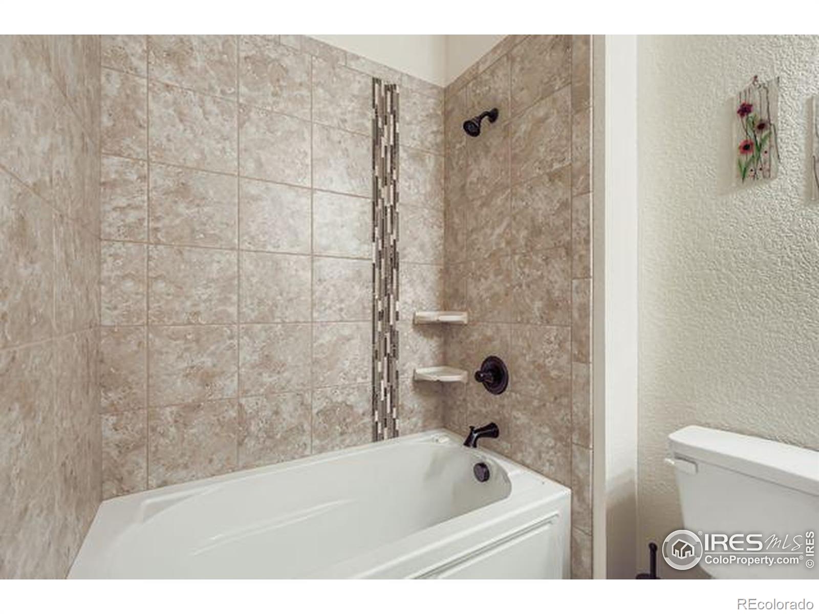 3453 Rhea Drive Loveland, CO 80537 - Photo 20 of 33 a bathroom with a bathtub and a toilet