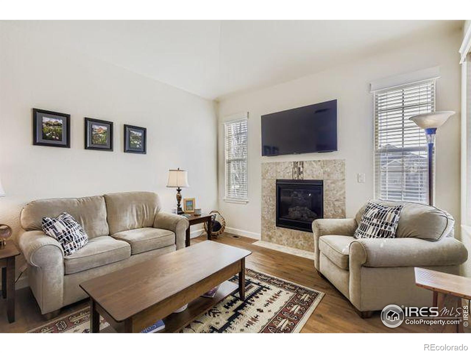 3453 Rhea Drive Loveland, CO 80537 - Photo 5 of 33 a living room with furniture a flat screen tv and a fireplace