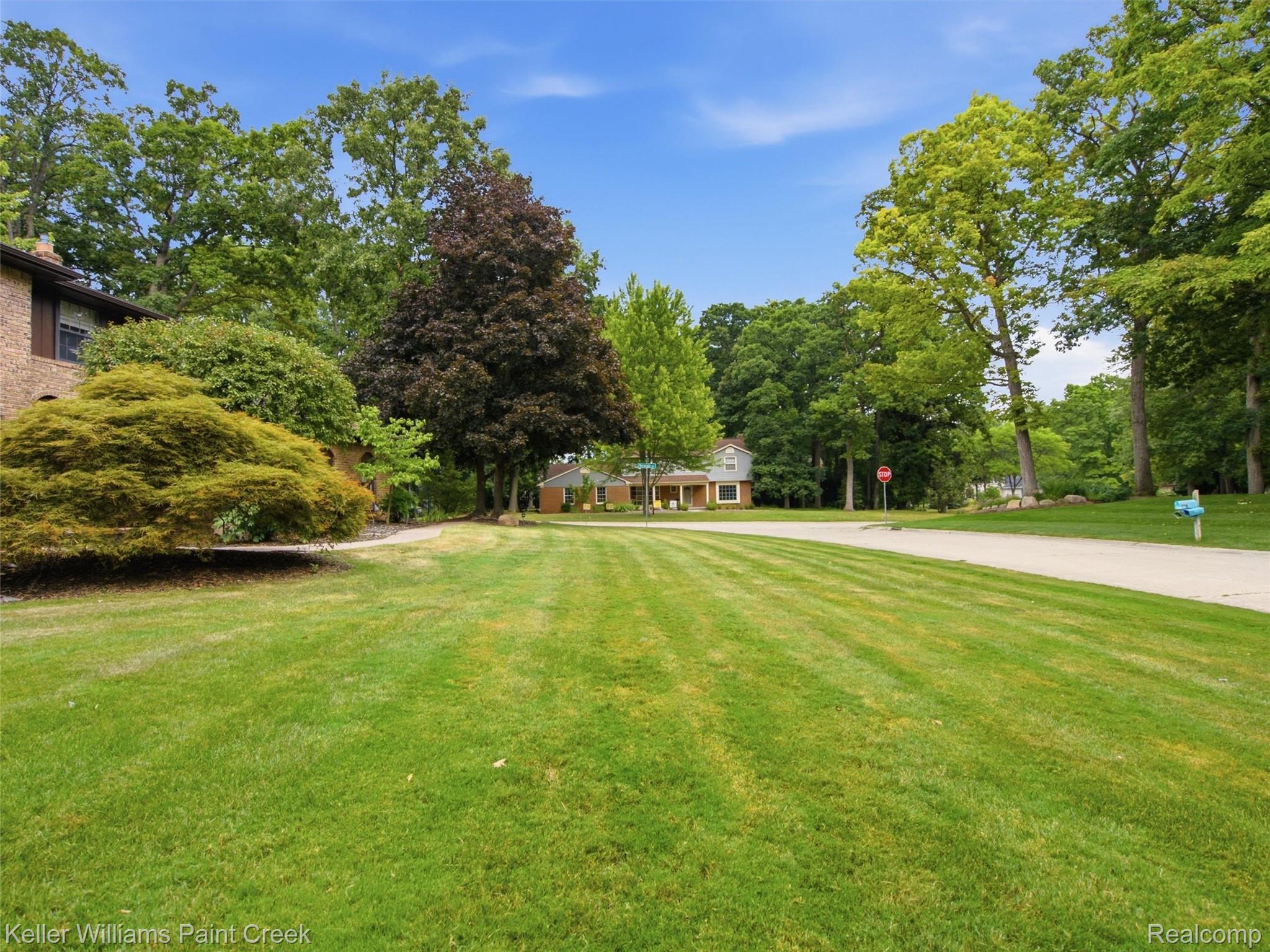 2950 Leyton Court Rochester, MI 48306 - Photo 45 of 46 Expansive lawn with mature trees and a paved street