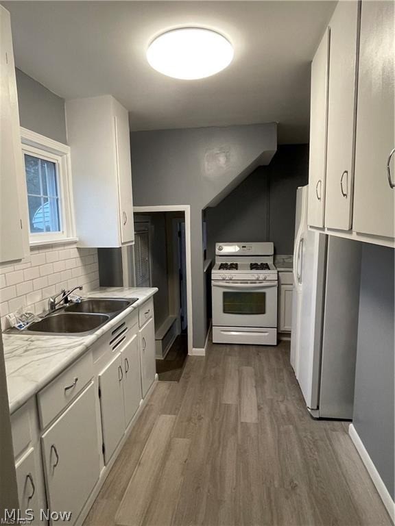 2800 Hillside Road Seven Hills, OH 44131 - Photo 6 of 18 Kitchen featuring Vinyl Flooring, white cabinetry, a dual basin stainless steel sink, and a subway tile backsplash