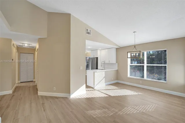 a view of a kitchen with wooden floor and a window