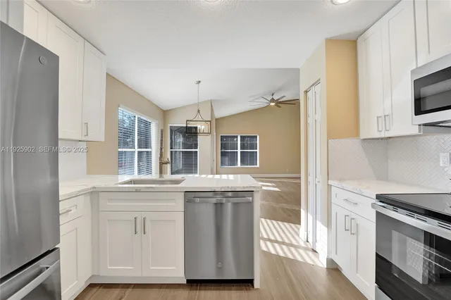 a kitchen with stainless steel appliances granite countertop a stove and a microwave