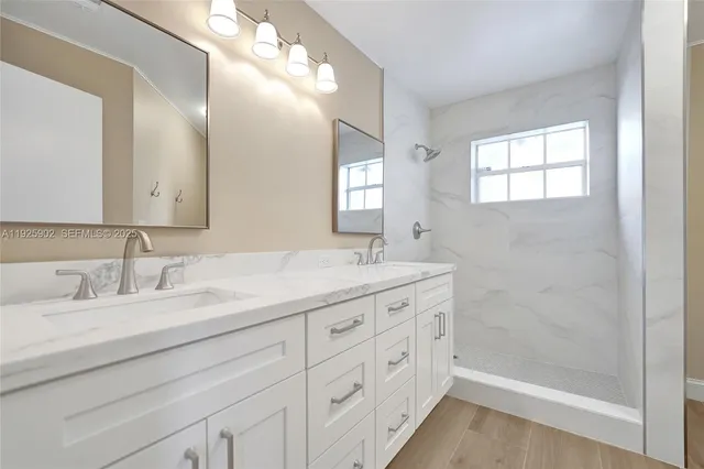 a bathroom with double sink and a mirror
