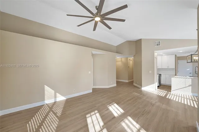 a view of a big room with wooden floor and a ceiling fan