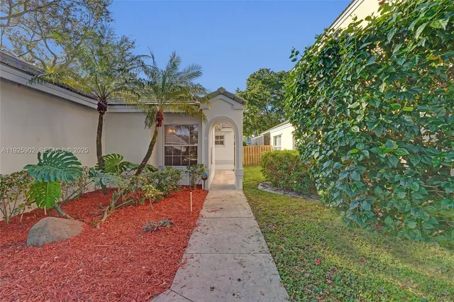 a front view of a house with a yard and potted plants