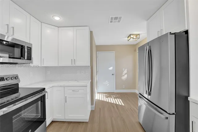 a kitchen with stainless steel appliances a refrigerator sink and microwave