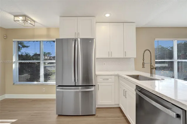 a kitchen with a refrigerator sink and cabinets