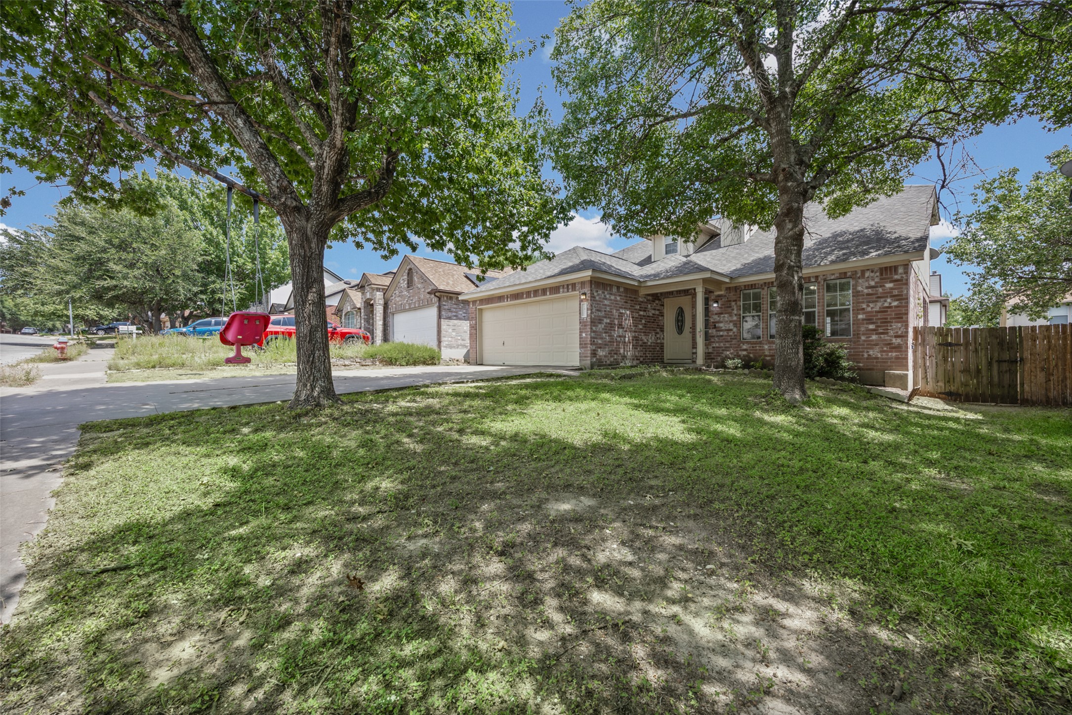 2432 Roundabout Lane Round Rock, TX 78664 - Photo 2 of 22 A classic brick exterior with an attached garage and mature shade trees, offering inviting curb appeal.