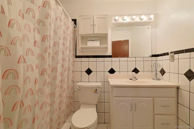 a bathroom with a sink a toilet and mirror