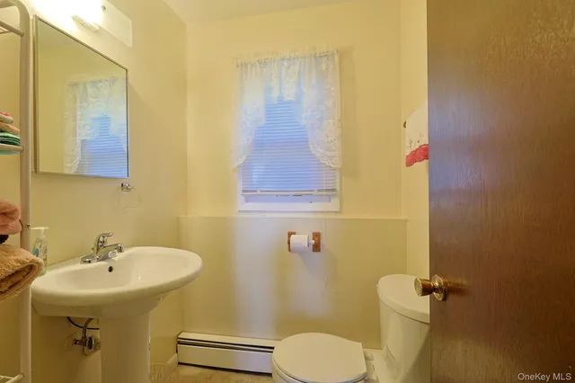 a bathroom with a sink toilet and mirror