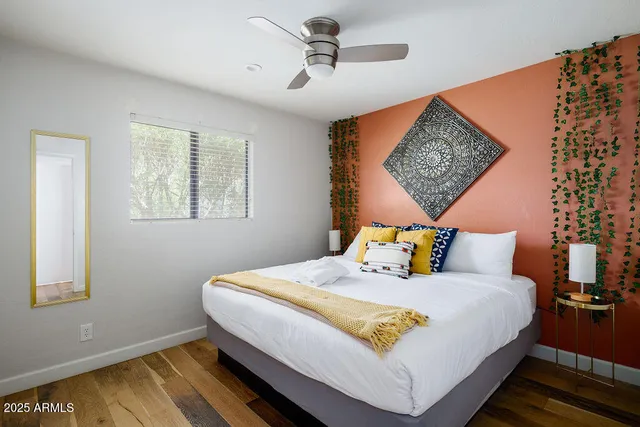 a bedroom with a bed a rug and painting on the wall