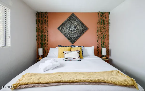 a bed sitting in a bedroom next to a window
