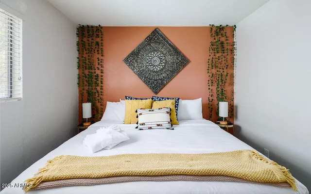 a bed sitting in a bedroom next to a window