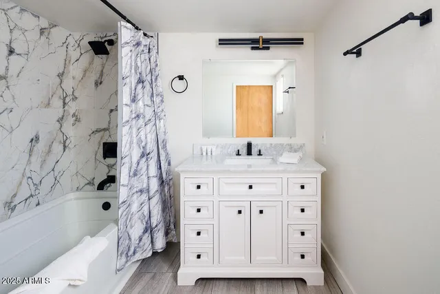 a bathroom with a tub sink and mirror
