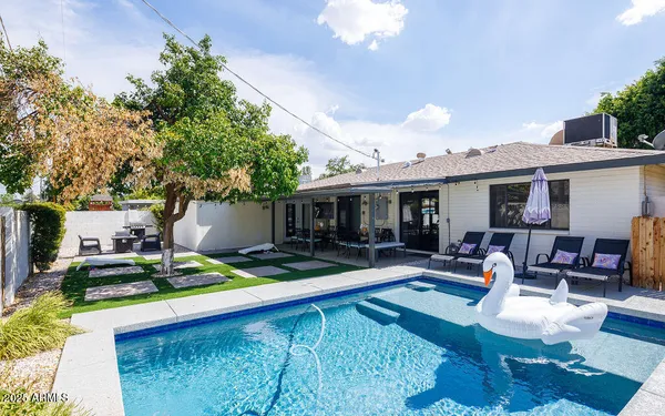 a view of a house with swimming pool and sitting area