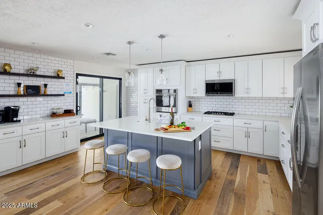 a kitchen with granite countertop a sink stove and wooden floor
