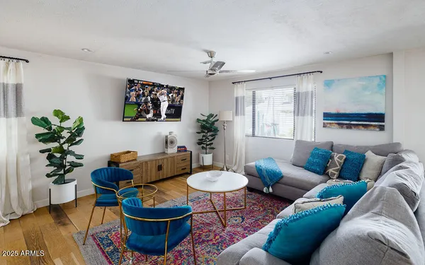 a living room with furniture a chandelier and a potted plant