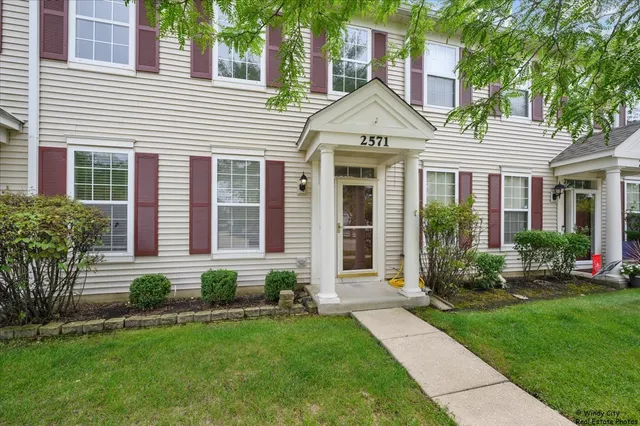 a front view of a house with a yard and plants