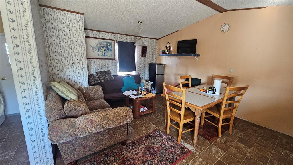 413 Lakeview Trail Weatherford, TX 76087 - Photo 17 of 40 a dining room with furniture and a flat screen tv