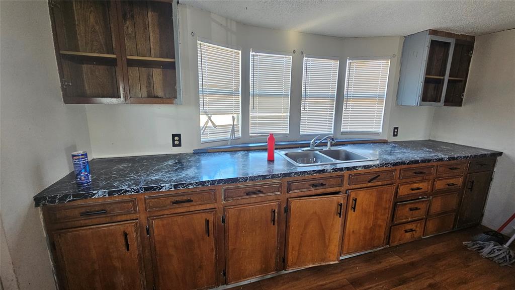 413 Lakeview Trail Weatherford, TX 76087 - Photo 29 of 40 a kitchen with granite countertop a sink a counter space and cabinets