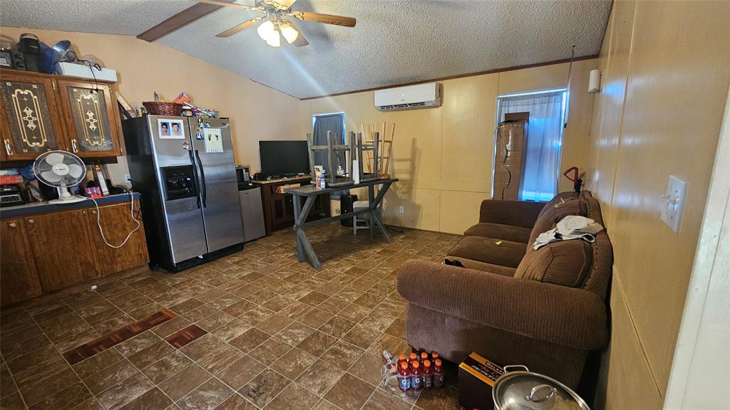 413 Lakeview Trail Weatherford, TX 76087 - Photo 5 of 40 a living room with furniture a flat screen tv and a refrigerator