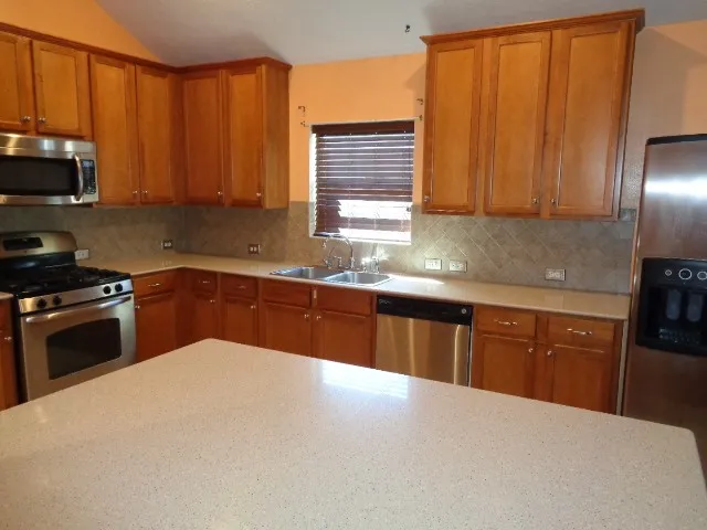 a kitchen with stainless steel appliances granite countertop a sink a stove and cabinets