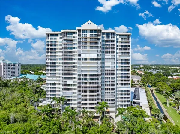 a front view of a multi story residential apartment building with a yard