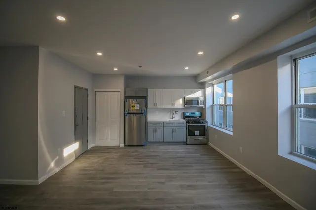 a open kitchen with stainless steel appliances granite countertop a refrigerator and a stove top oven
