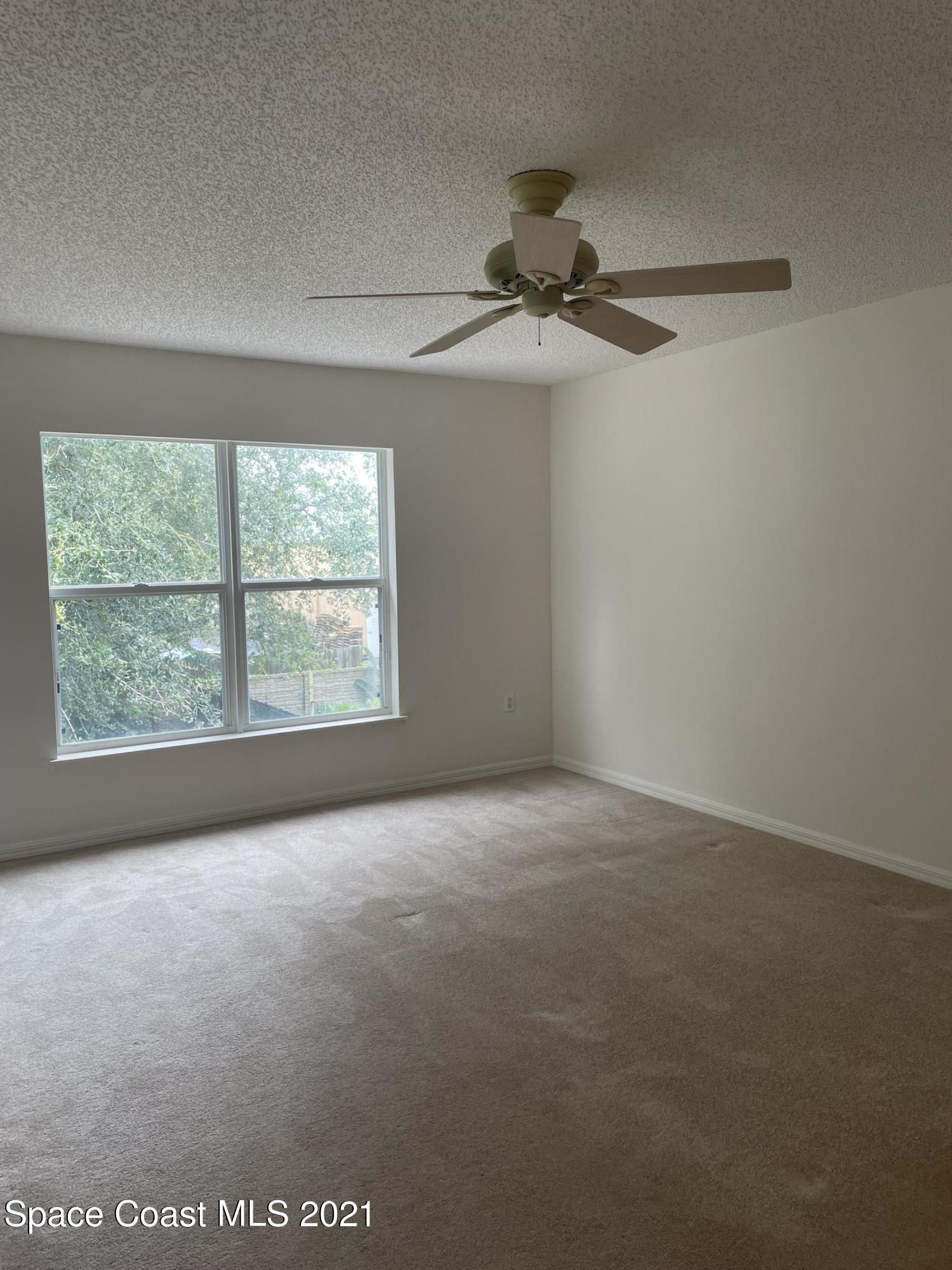 2315 Canopy Drive Melbourne, FL 32935 - Photo 11 of 27 an empty room with windows and fan