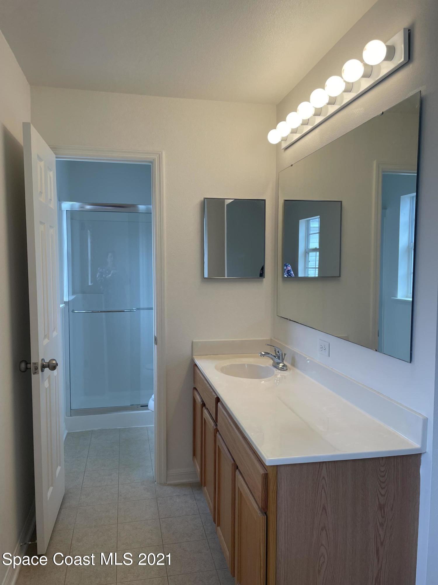 2315 Canopy Drive Melbourne, FL 32935 - Photo 14 of 27 a bathroom with a sink a vanity and a mirror