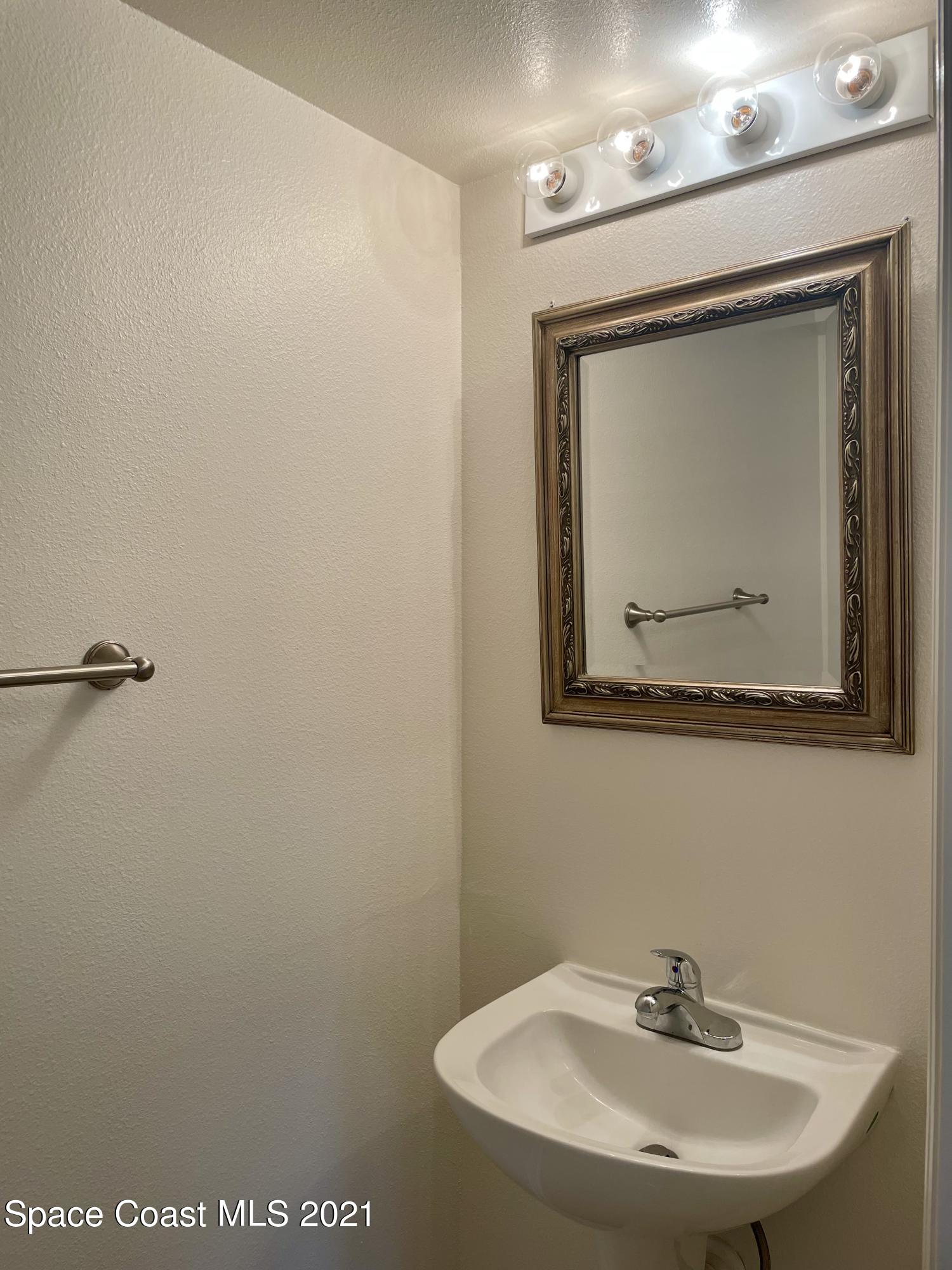 2315 Canopy Drive Melbourne, FL 32935 - Photo 8 of 27 a bathroom with a sink mirror and vanity