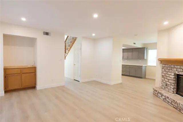 an empty room with kitchen and entrance