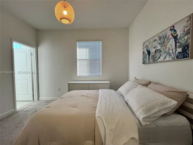 a bedroom with a bed and painting on the wall