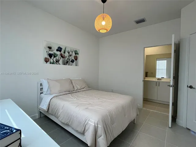 a bedroom with a bed and painting on the wall