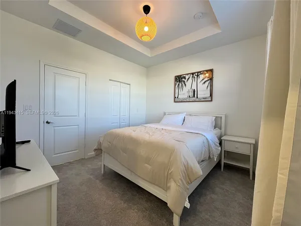 a bedroom with a bed and a flat screen tv