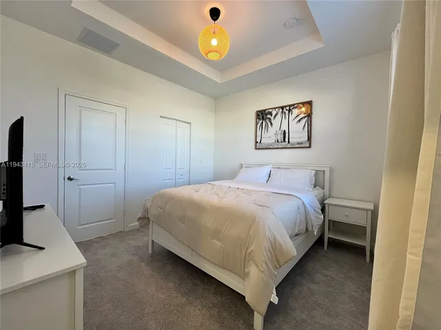 a bedroom with a bed and a flat screen tv