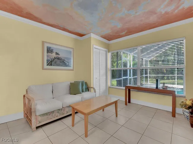 a living room with furniture a table and a large window