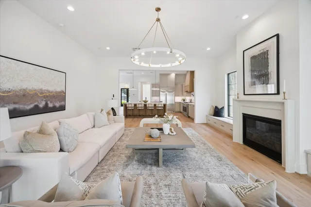 a living room with furniture a fireplace and a chandelier