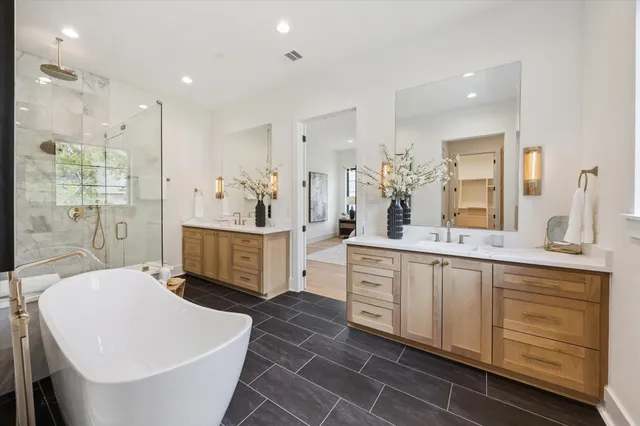 a large bathroom with a double vanity sink a mirror and a bathtub