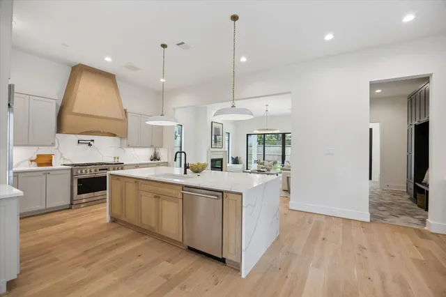 a kitchen with a sink stove and wooden floor
