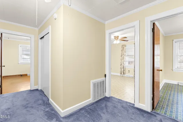 a view of a hallway with wooden floor and a living room