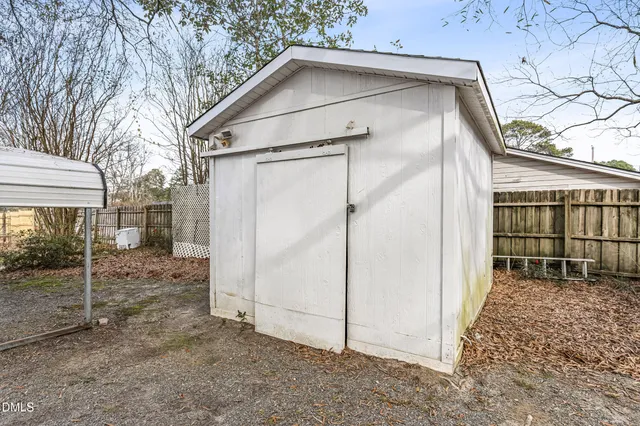 a view of a house with a door and wooden fence